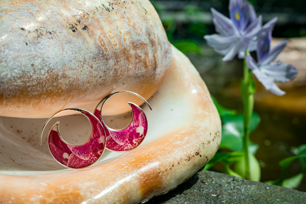 pair of orchid hoop earrings in a seashell