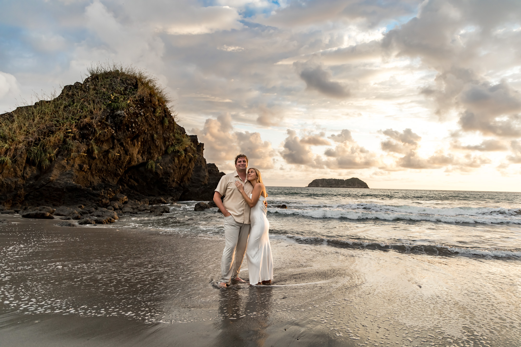 couple kissing as the ocean rolls in